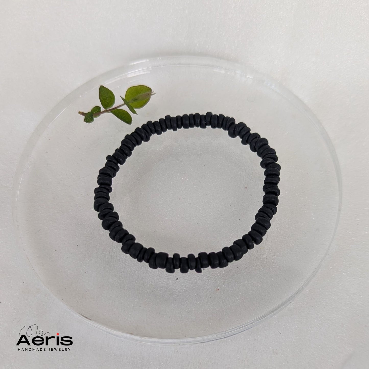 Bratara handmade pe elastic cu margele negre din cocos, in forma de discuri neregulate