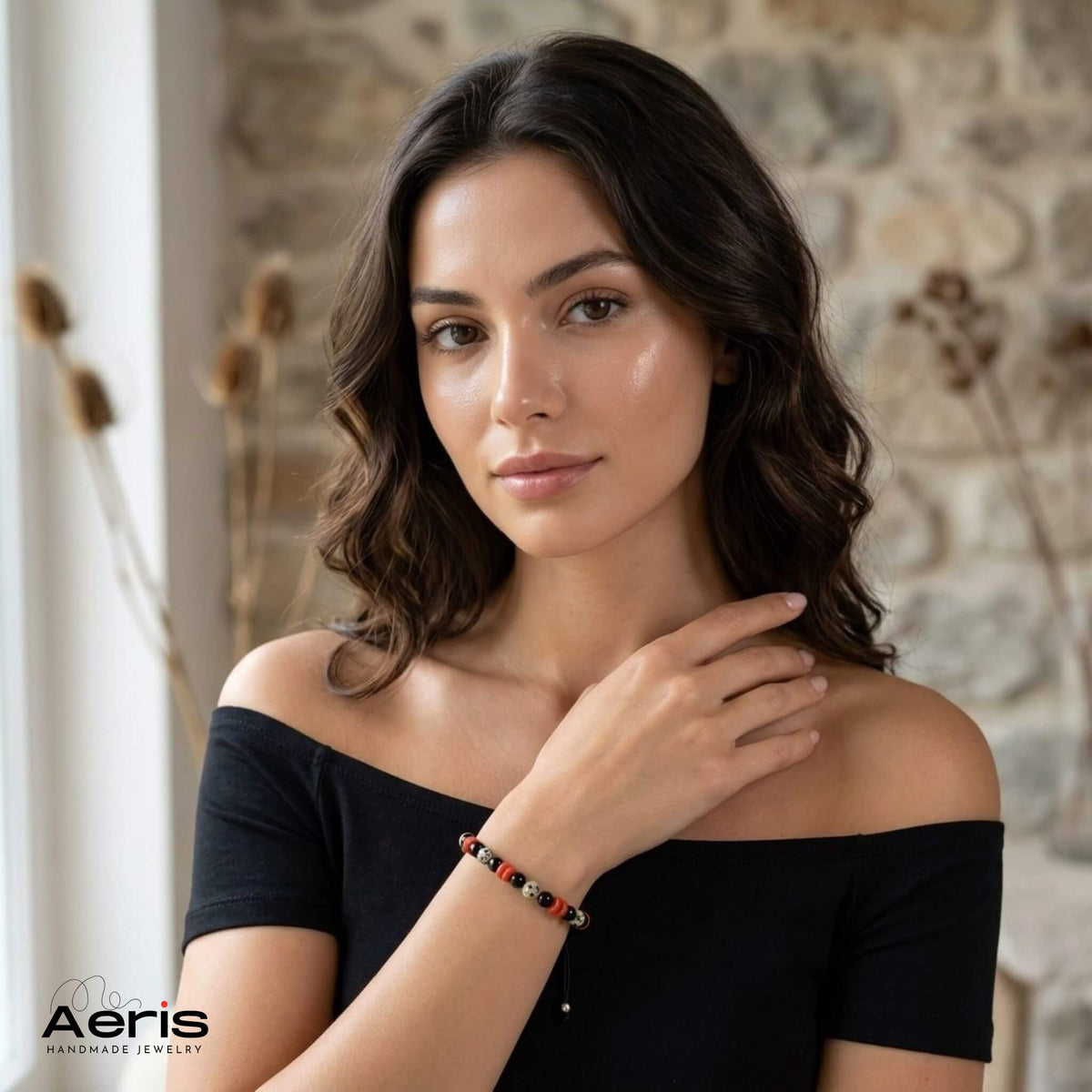 Tanara eleganta in rochie neagra, purtand pe incheietura mainii bratara cu pietre semipretioase multicolore