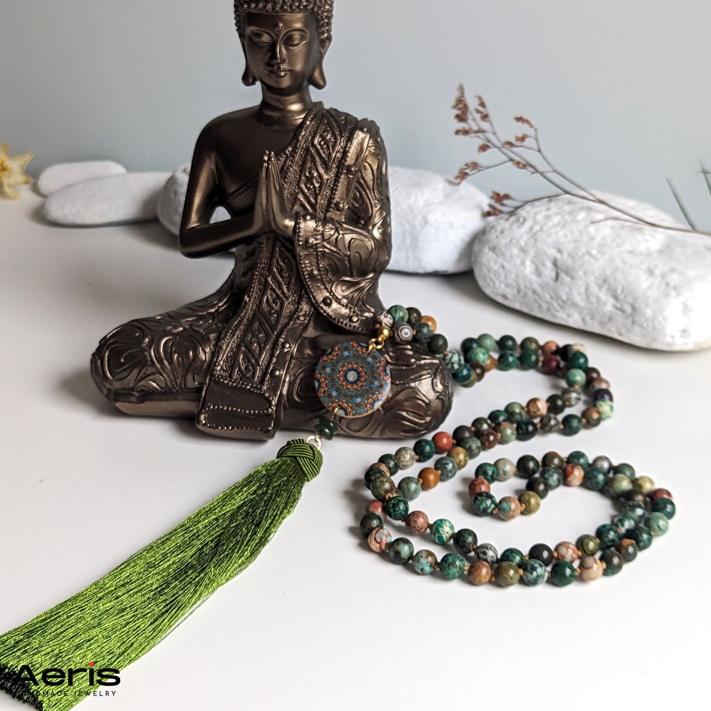 Colier mala multicolor, langa statuie reprezentand pe Budha
