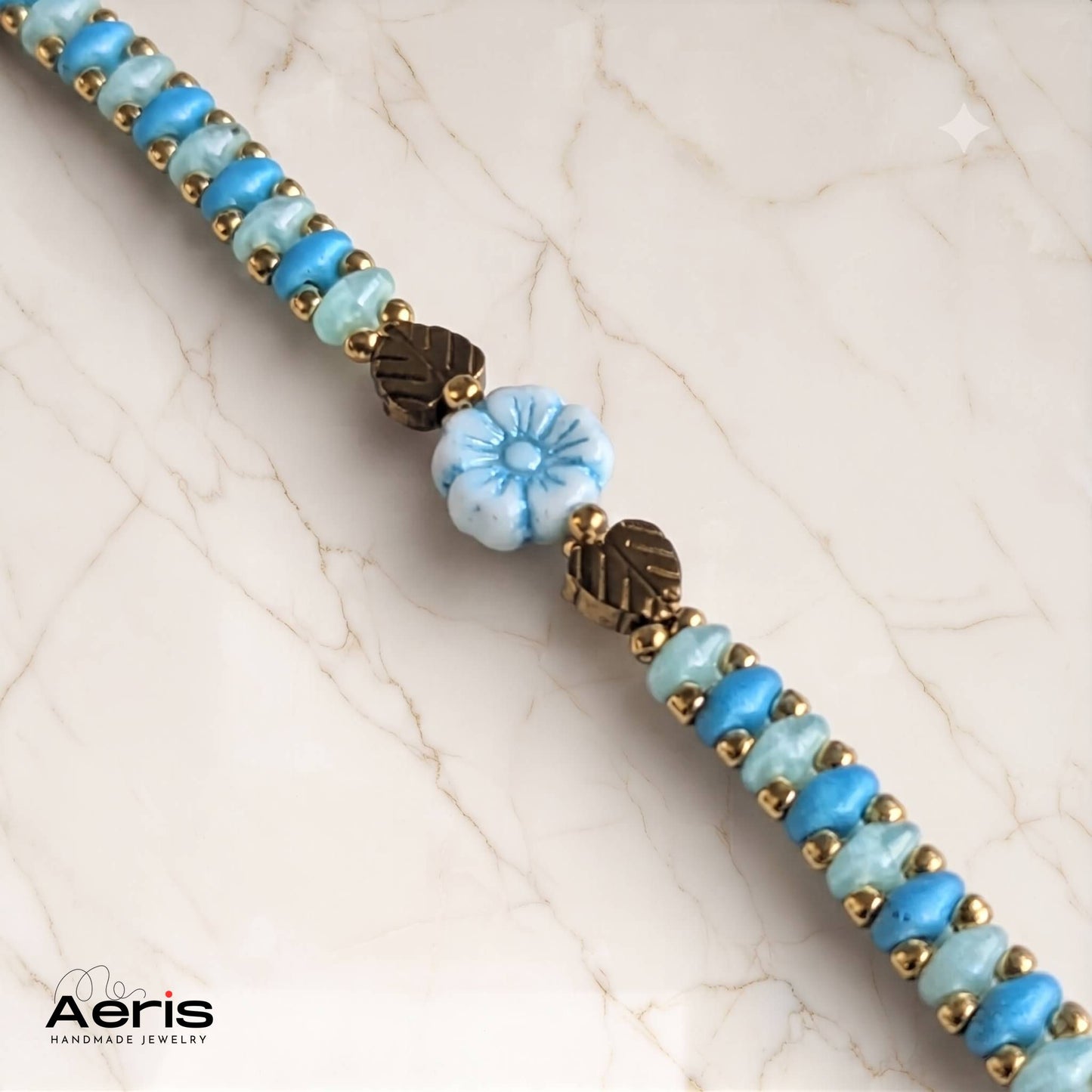 Detaliu al bratarii handmade cu margele bleu si accente aurii