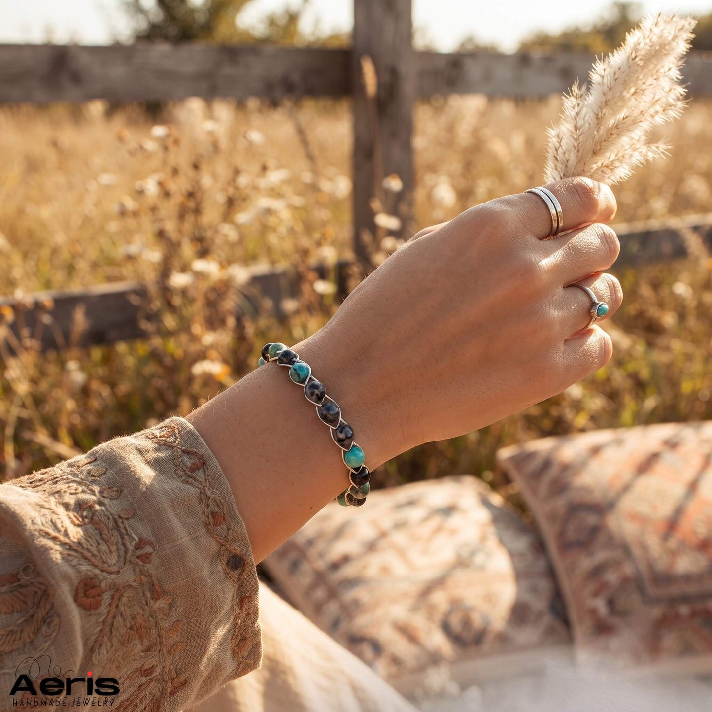 Bratara artizanala purtata de femeie in tinuta boema intr-un cadru natural