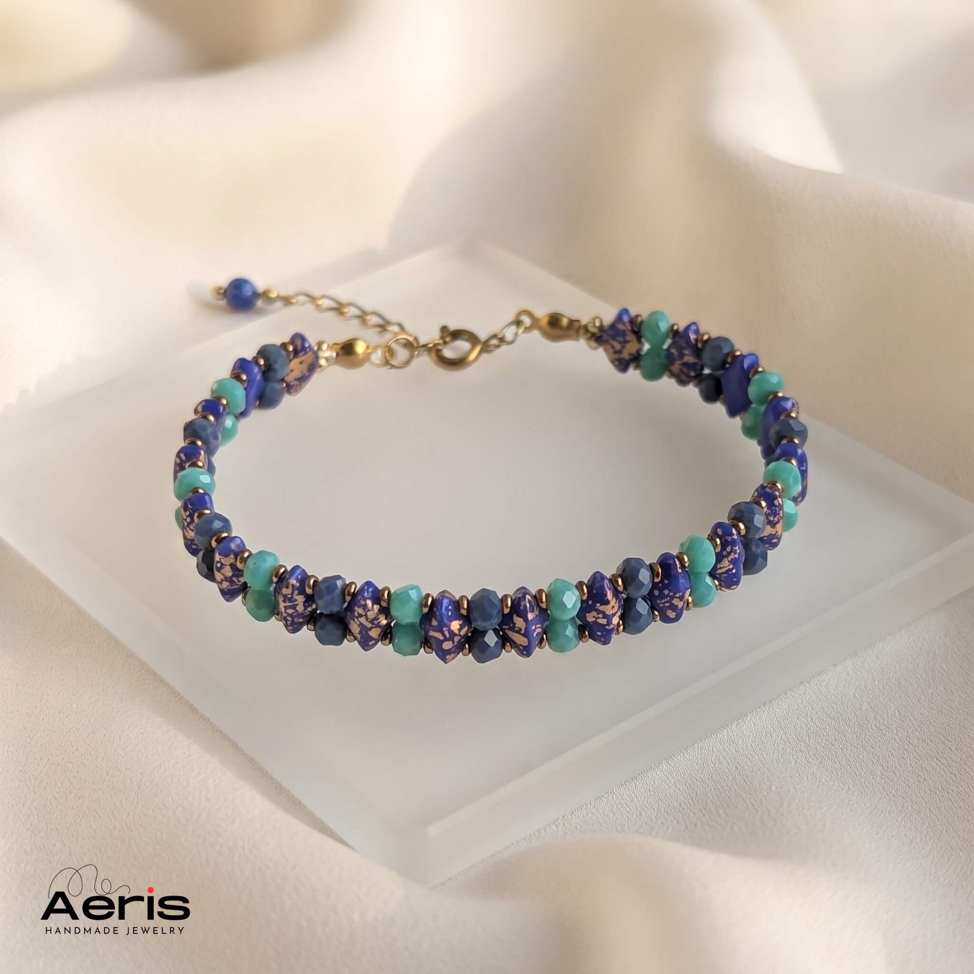 Bratara handmade delicata, prezentata pe un soclu din sticla mata