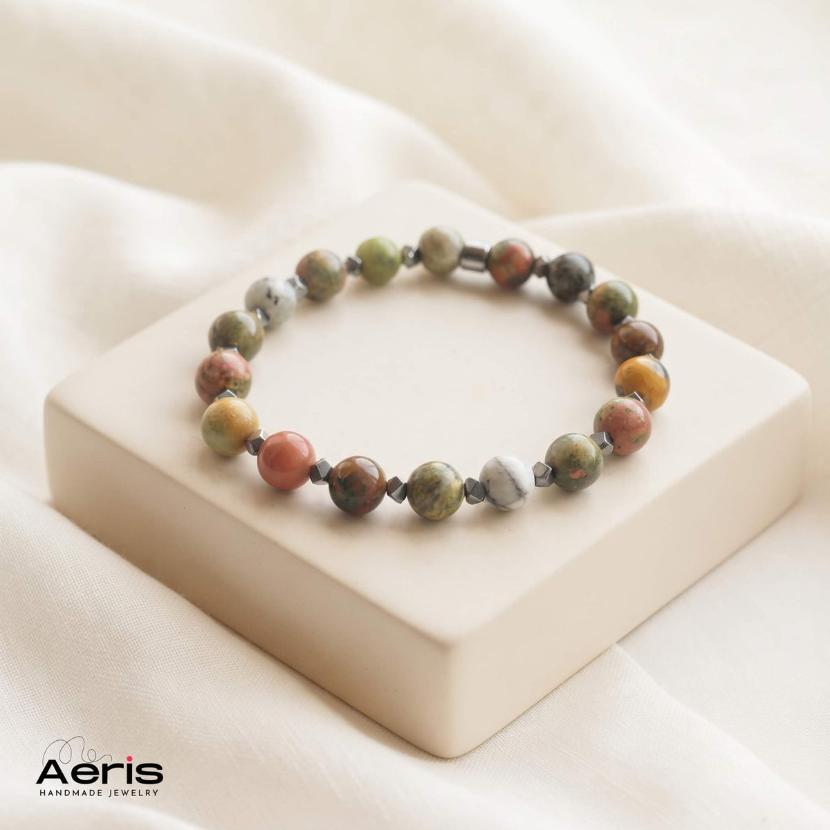 Bratara handmade pe elastic, din jasp multicolor si distantiere fatetate din hematit