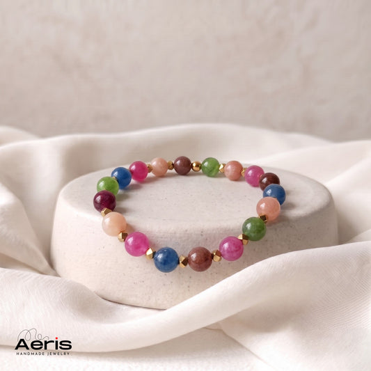 Bratara handmade multicolora din margele semipretioase, expusa pe un suport rotund din ceramica