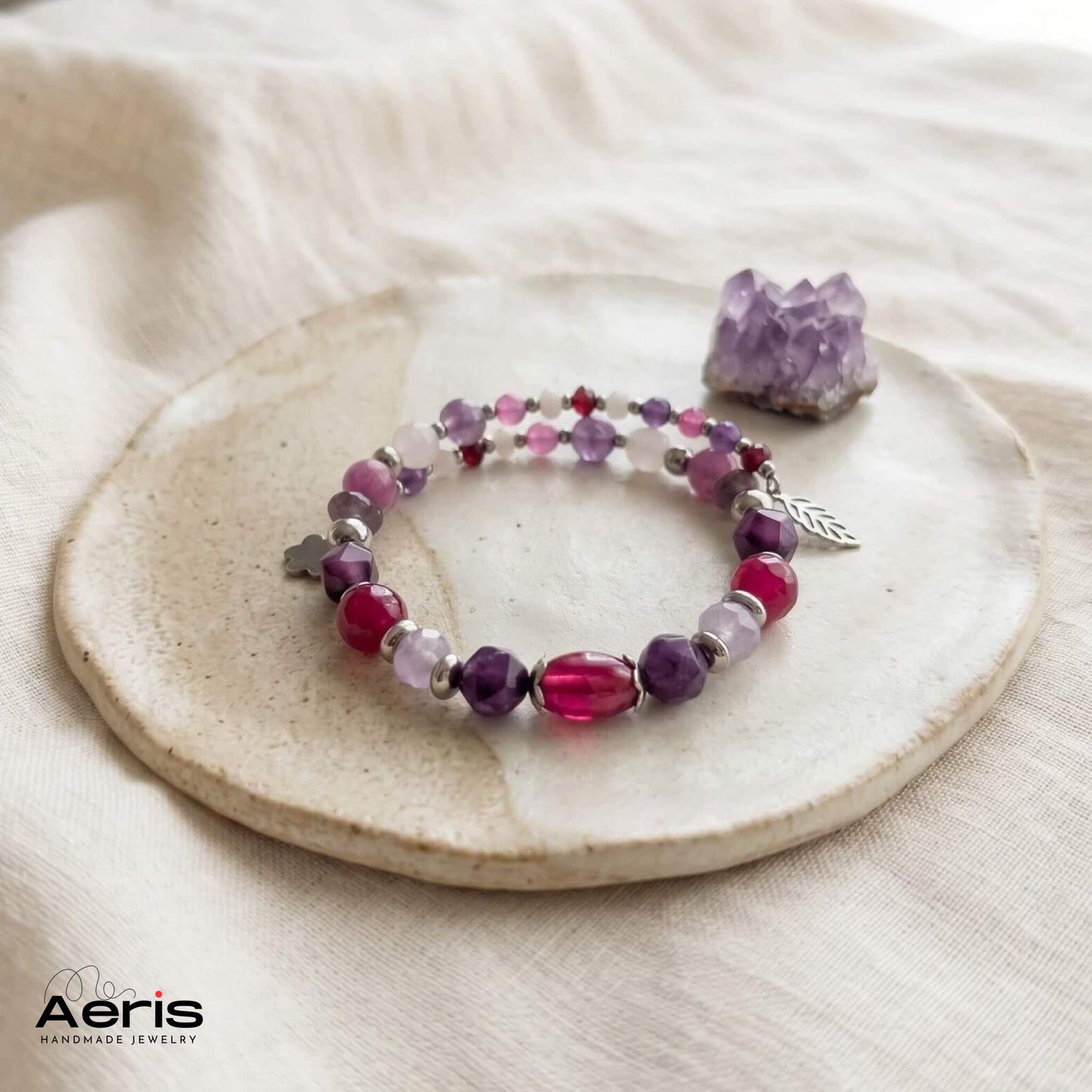 Bratara handmade cu margele semipretioase in culori combinate mov si fucsia, prezentata pe un pad ceramic