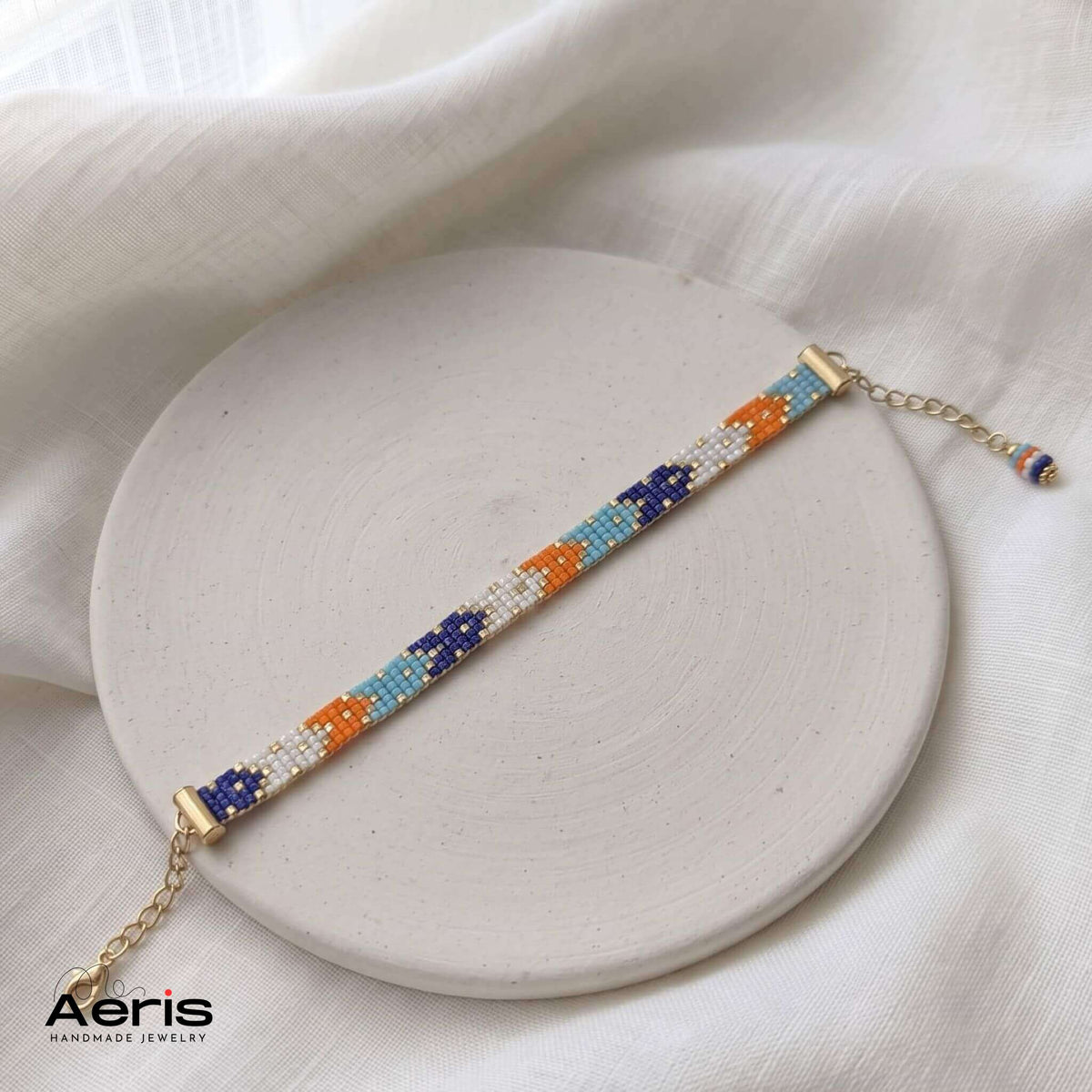 Bratara handmade multicolora cu margele Miyuki, prezentata pe un disc din ceramica mata