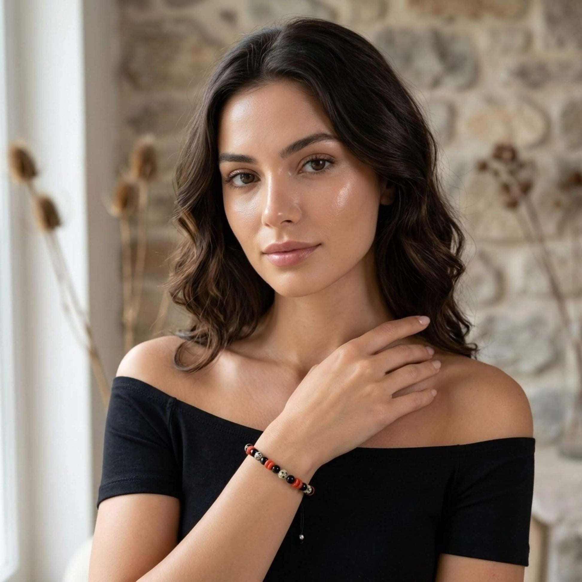 Tanara eleganta in rochie neagra, purtand pe incheietura mainii bratara cu pietre semipretioase multicolore