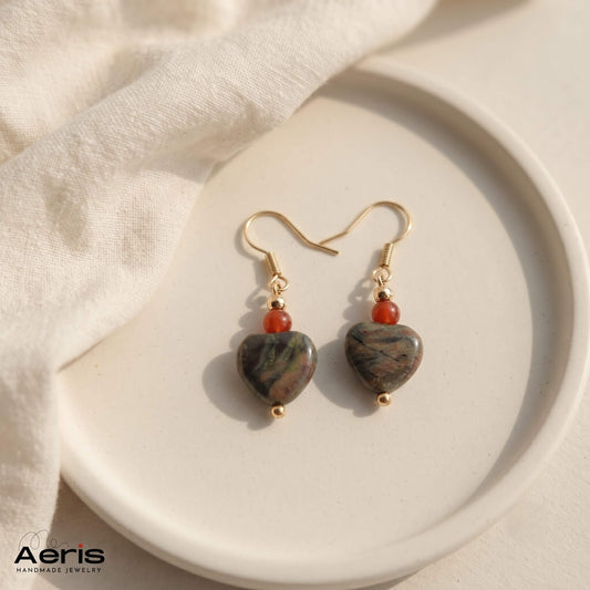 Cercei handmade cu margele semipretioase in forma de inima si tortite carlig din inox auriu. Prezentati pe un disc rotund din ceramica mata.