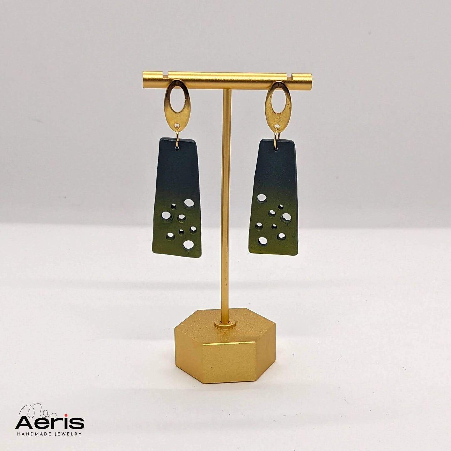 Cercei handmade eleganti, prezentati pe suport auriu