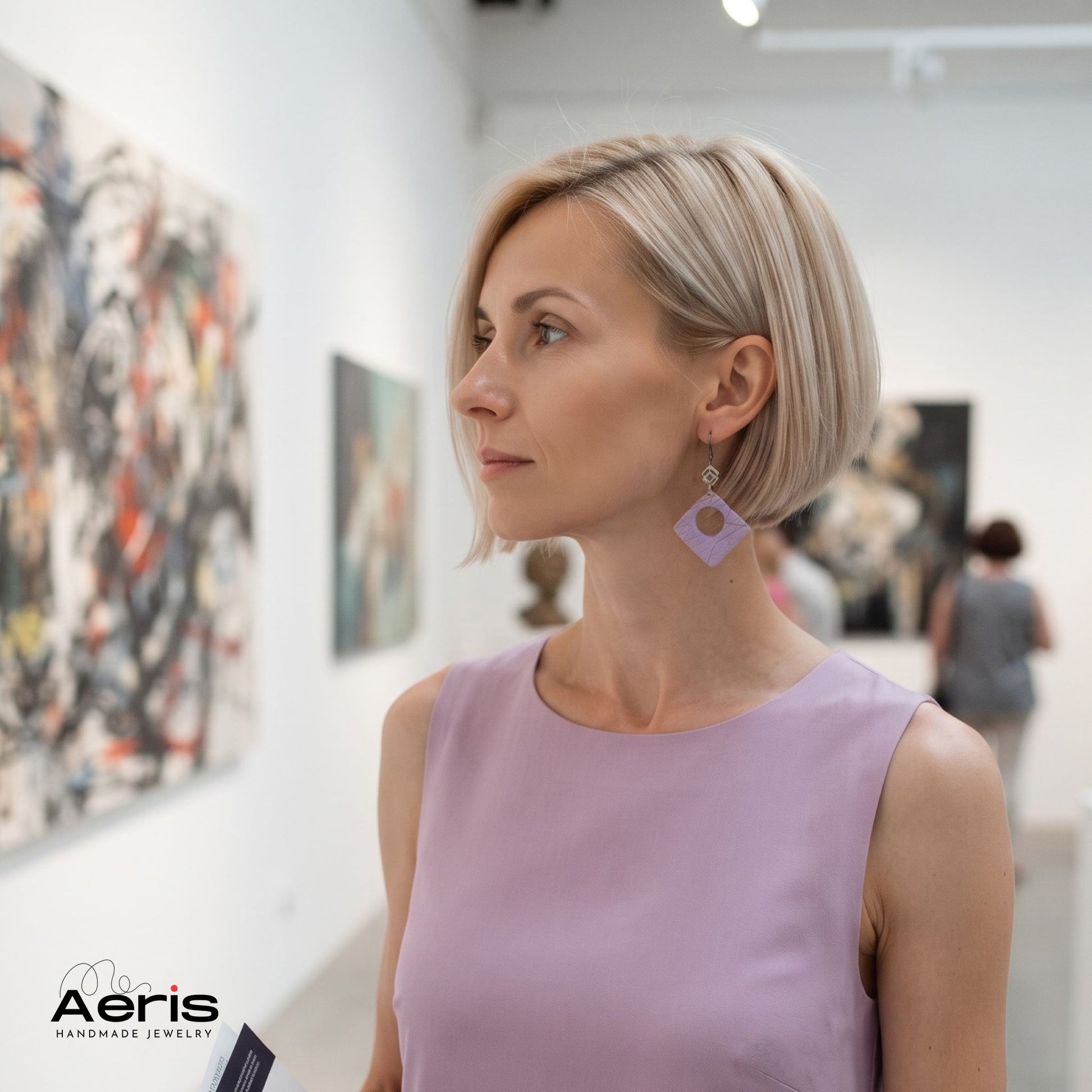 Femeie intr-o galerie de arta contemporana, purtand cerceii statement lila din lut polimeric, asortati la o rochie eleganta in aceeasi culoare