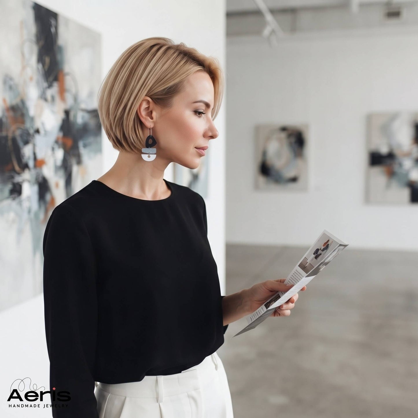 Femeie in tinuta smart casual vizitand o galerie de arta contemporana si purtand cerceii statement din lut polimeric