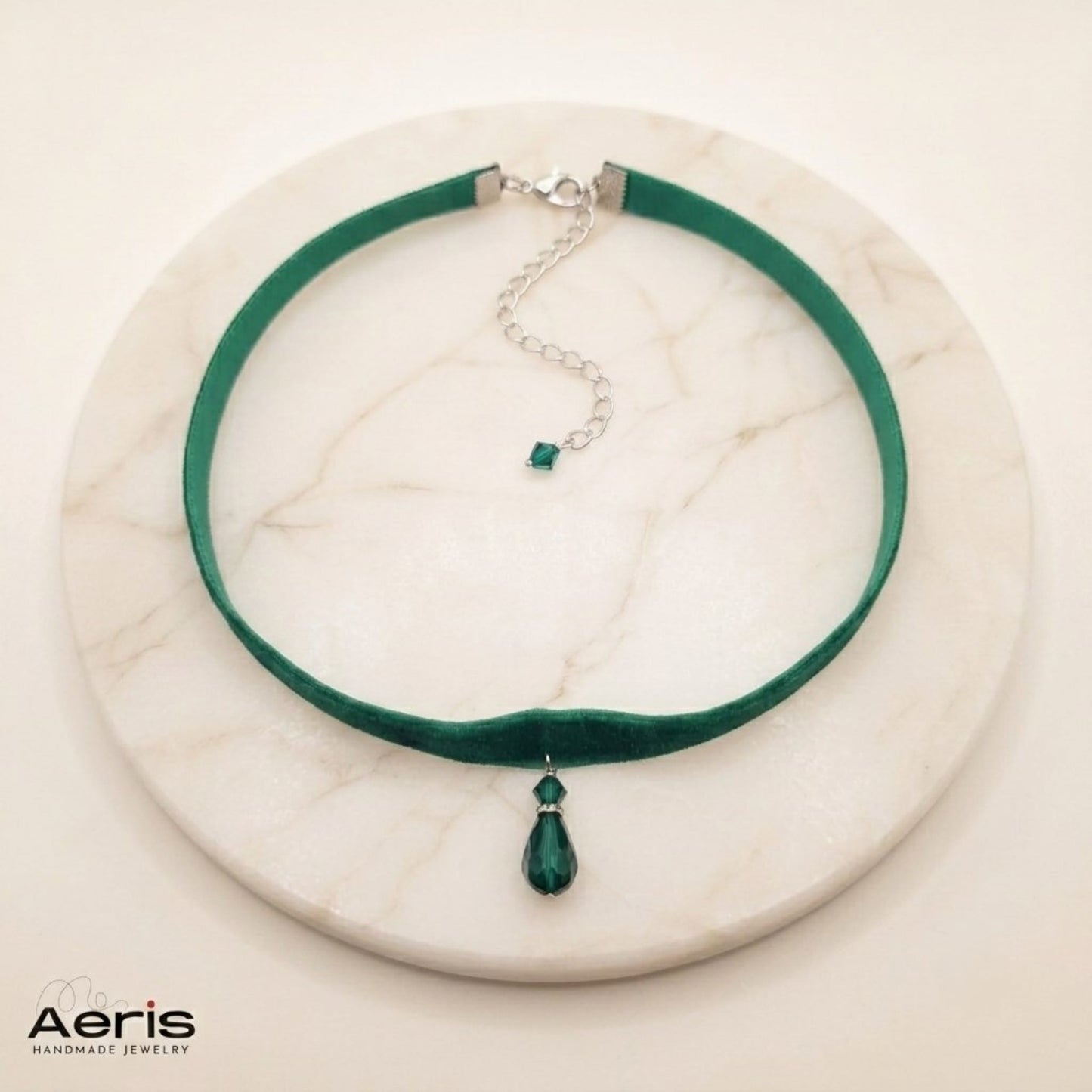 Colier la baza gatului din catifea verde smarald expus pe un soclu de marmura