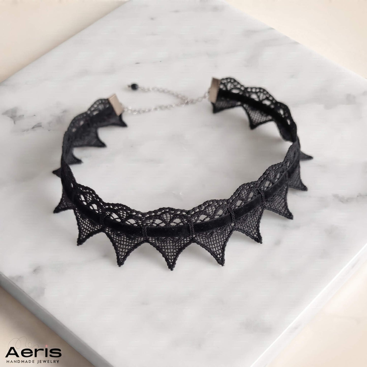 Chocker din dantela cu colturi, asezat pe o placa alba de marmura