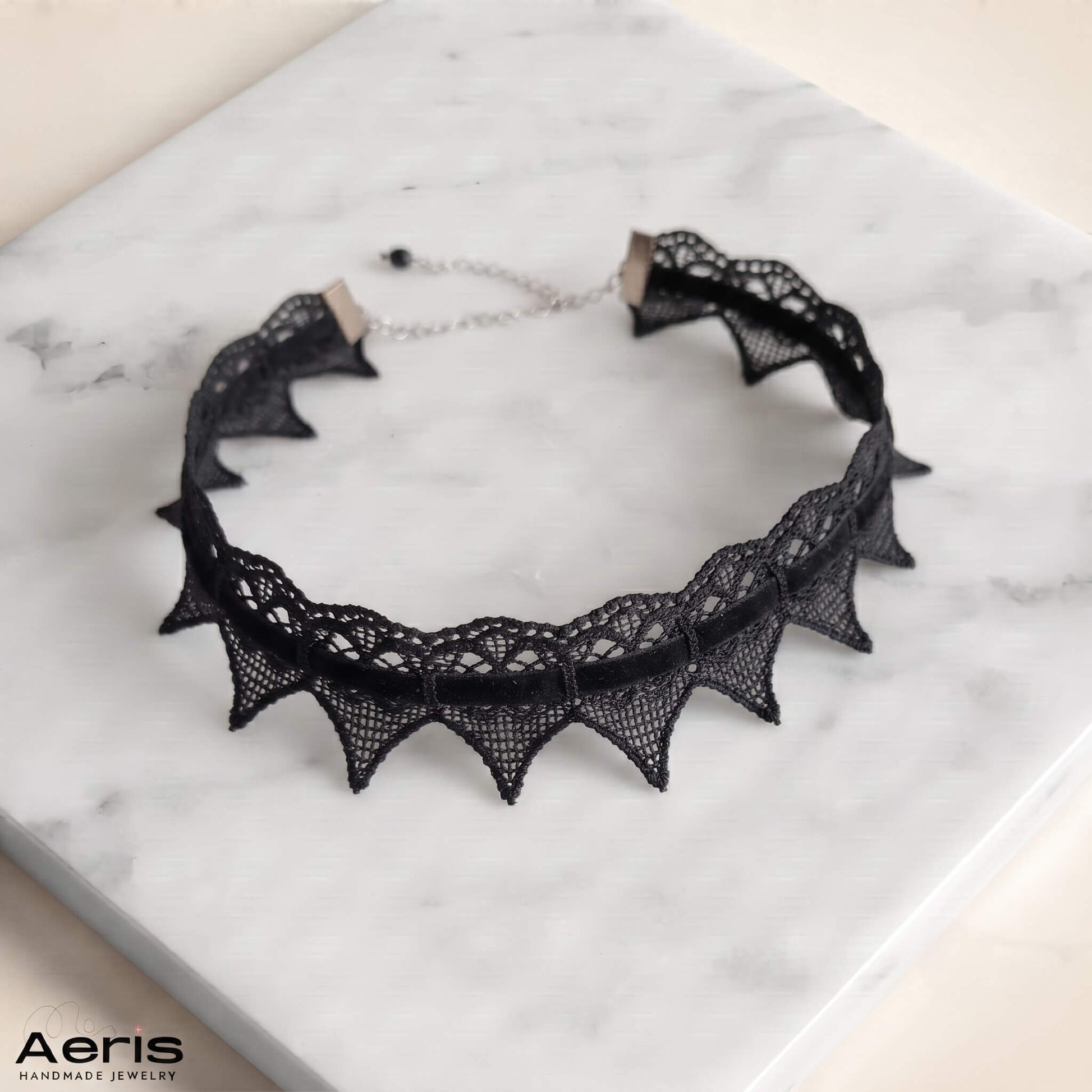 Chocker din dantela cu colturi, asezat pe o placa alba de marmura