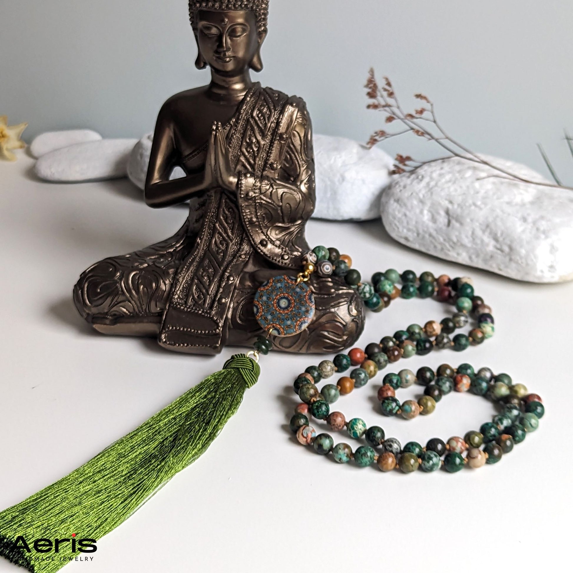 Colier mala multicolor, langa statuie reprezentand pe Budha