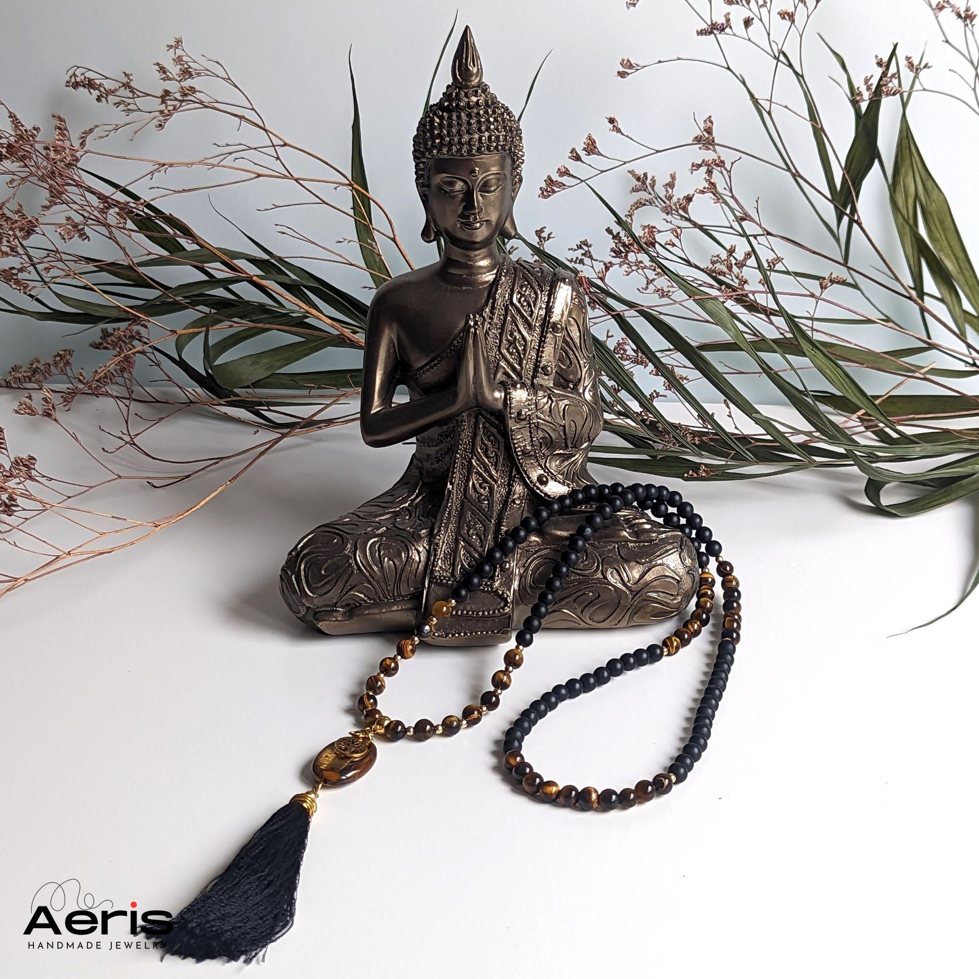 Colier cu copacul vietii asezat langa o statuie a lui Buddha