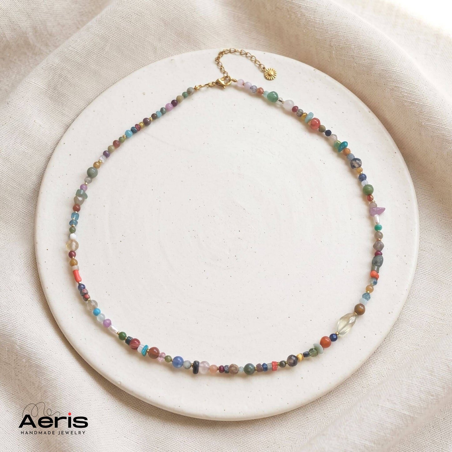 Colier handmade cu amestec inedit de pietre semipretioase, model unicat, prezentat pe un disc din ceramica mata