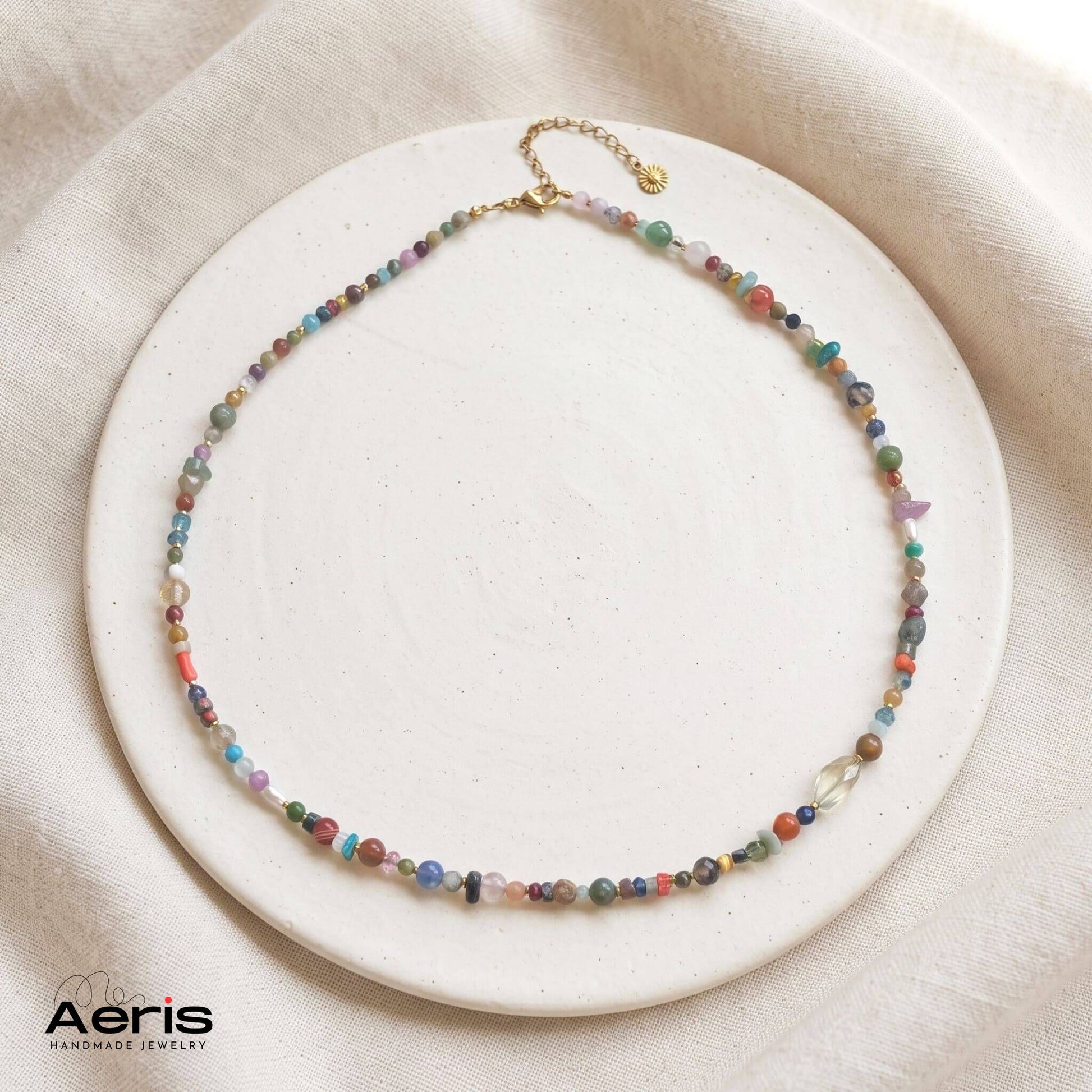 Colier handmade cu amestec inedit de pietre semipretioase, model unicat, prezentat pe un disc din ceramica mata