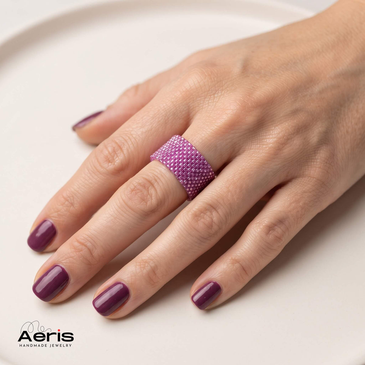 Inel fucsia transparent, elegant, cu detalii fine, prezentat pe mana unui model feminin