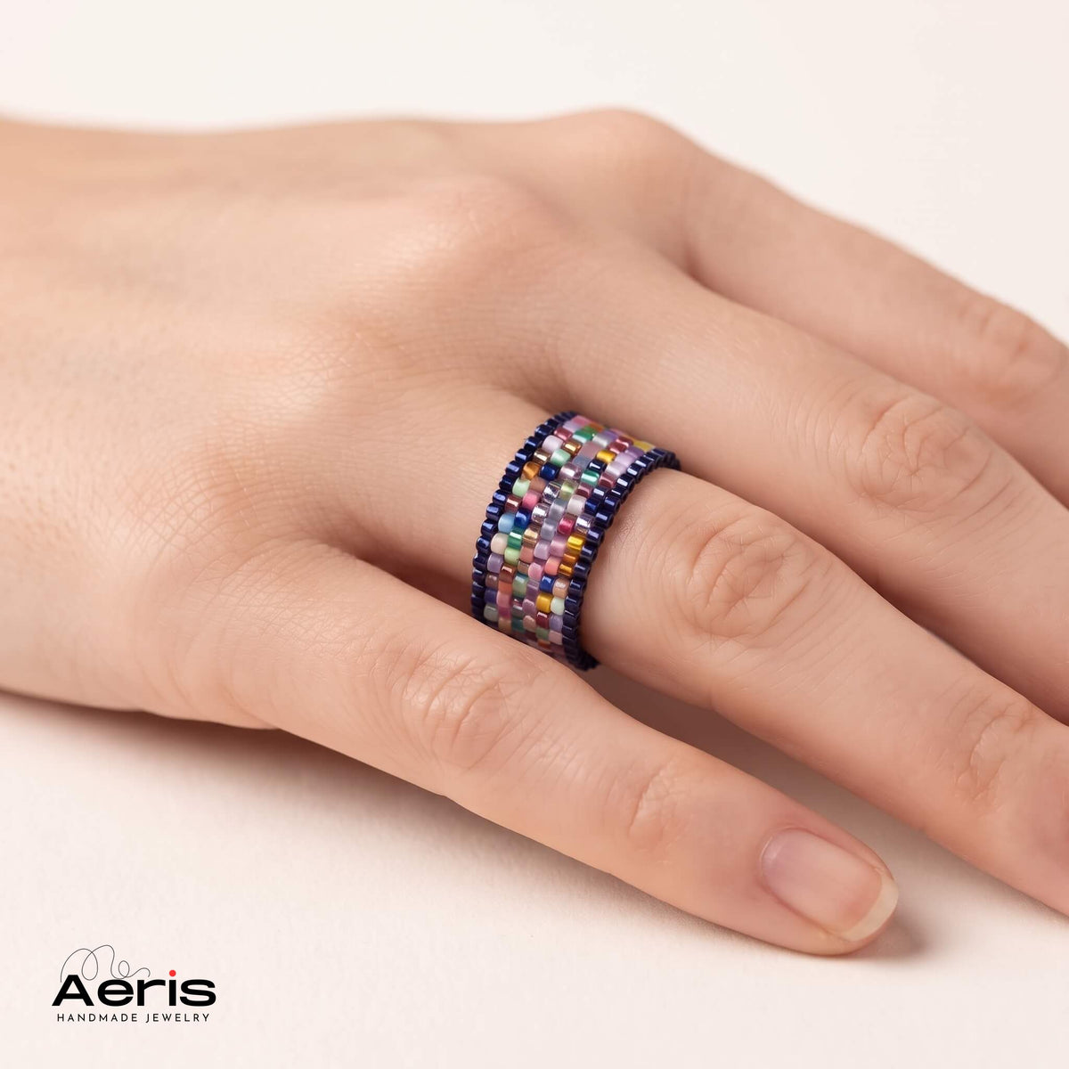 Inel multicolor cu detalii fine din margele Miyuki, purtat pe mana unui model feminin