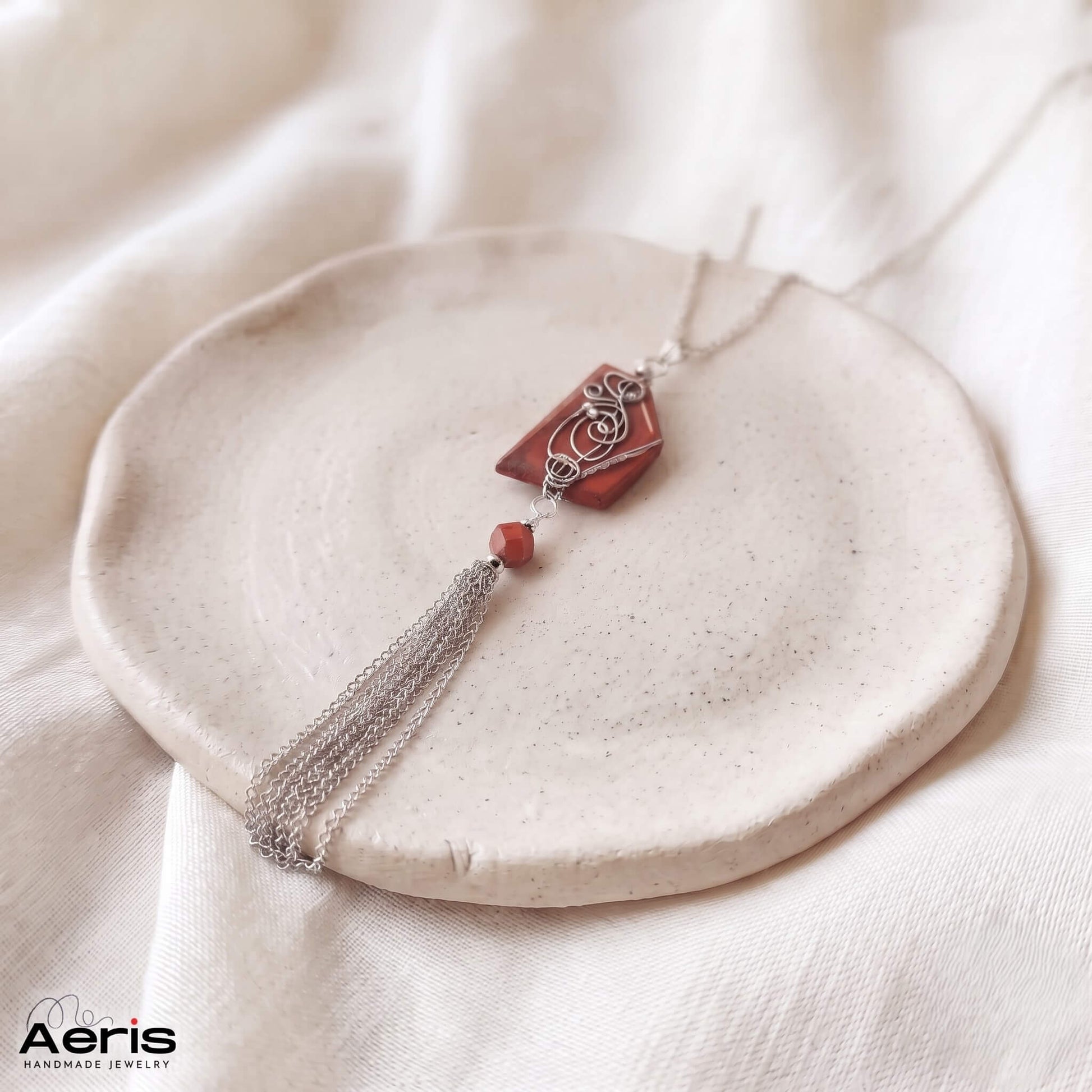Pandantiv unicat cu piatra naturala, prezentat pe un suport rotund ceramic