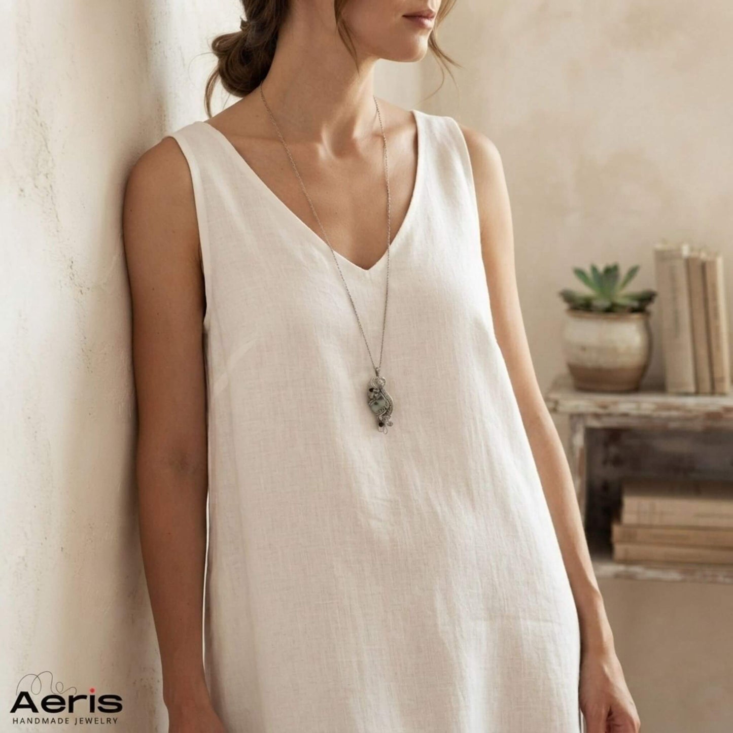 Femeie in interior minimalist, purtand pandantiv handmade cu jasp kiwi si onix negru