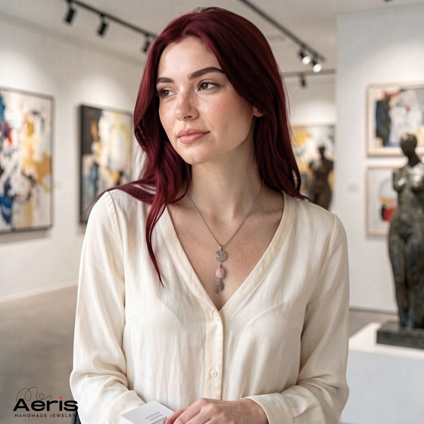 Femeie tanara intr-o galerie de arta, purtand pandantivul handmade cu kunzit si charmuri asortate